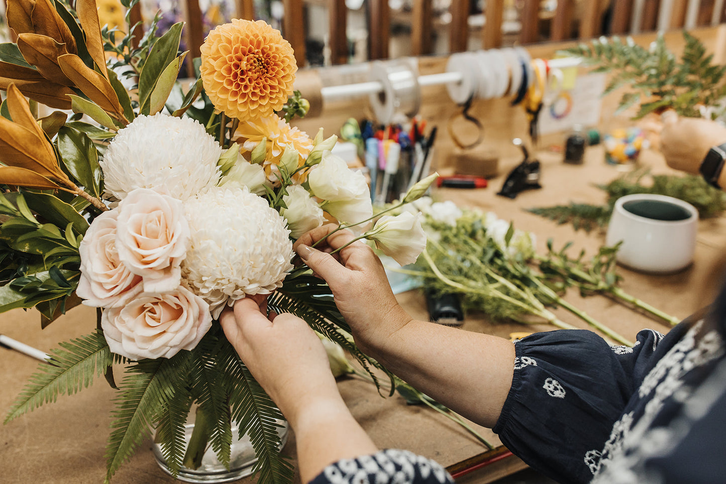 Our florist creating the luxe arrangement adding in a stem of lisianthus.