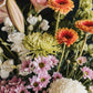 A tight close up view of the chrysanthemums, gerberas, lisianthus and lilies