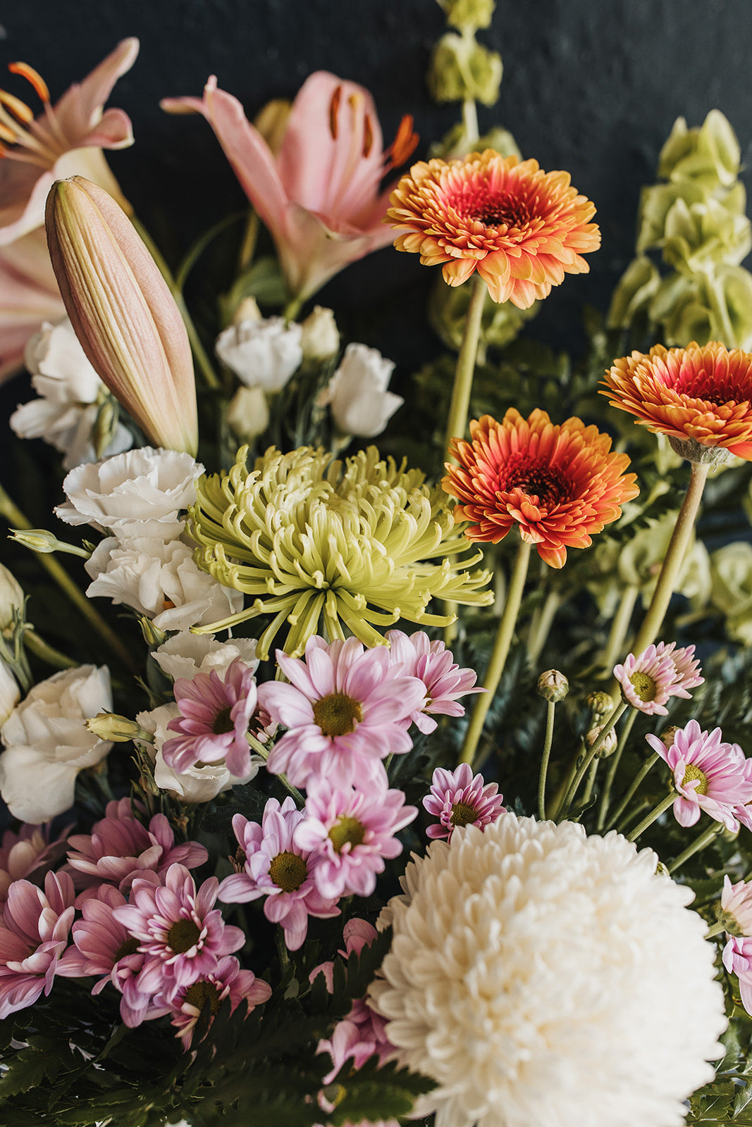 A tight close up view of the chrysanthemums, gerberas, lisianthus and lilies