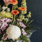 A closer view of the box arrangement with gerberas, chrysanthemums and fern foliage
