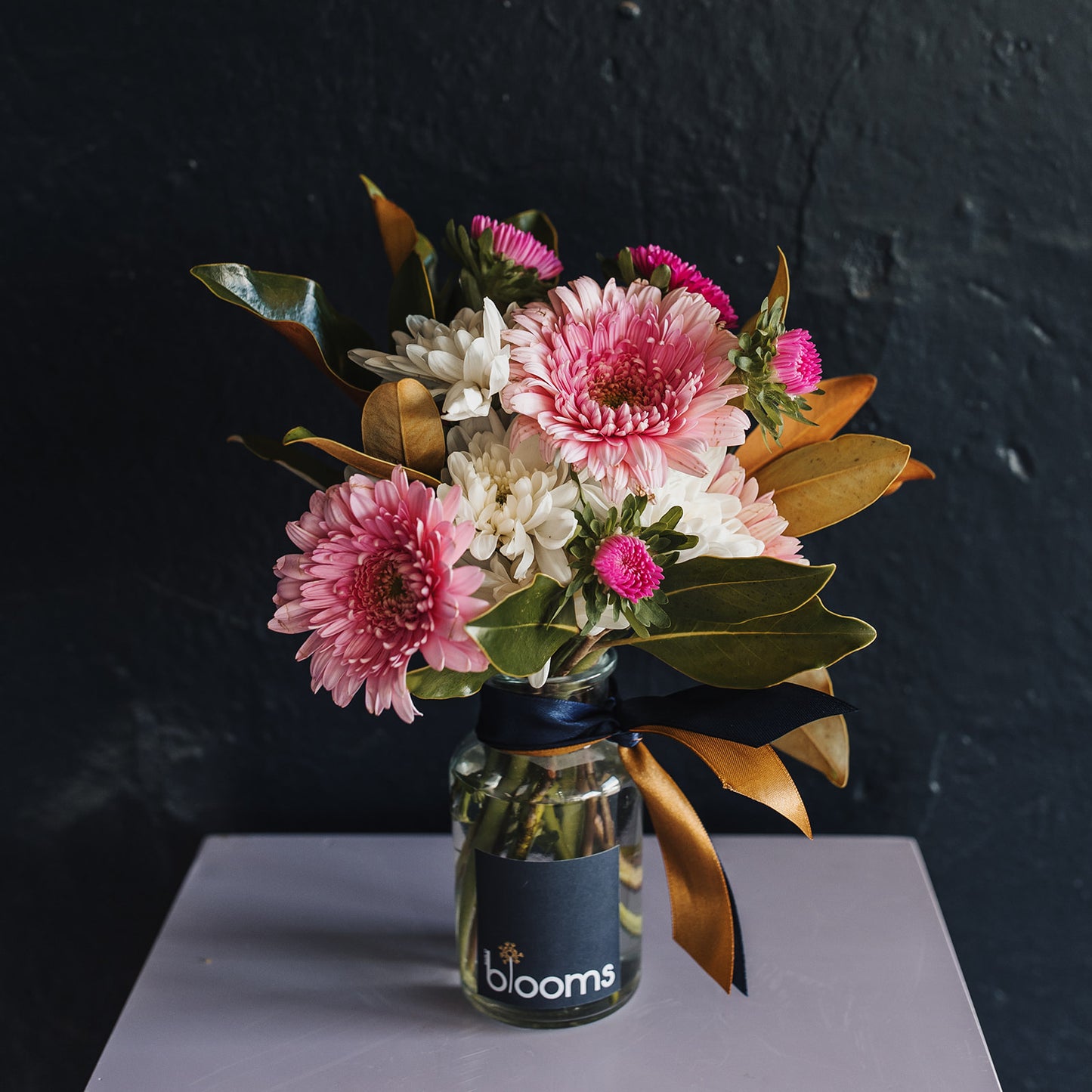 Seasonal bloom bottle. a mix of bright coloured flowers including chrysanthemums and gerberas. Clare flower delivery.